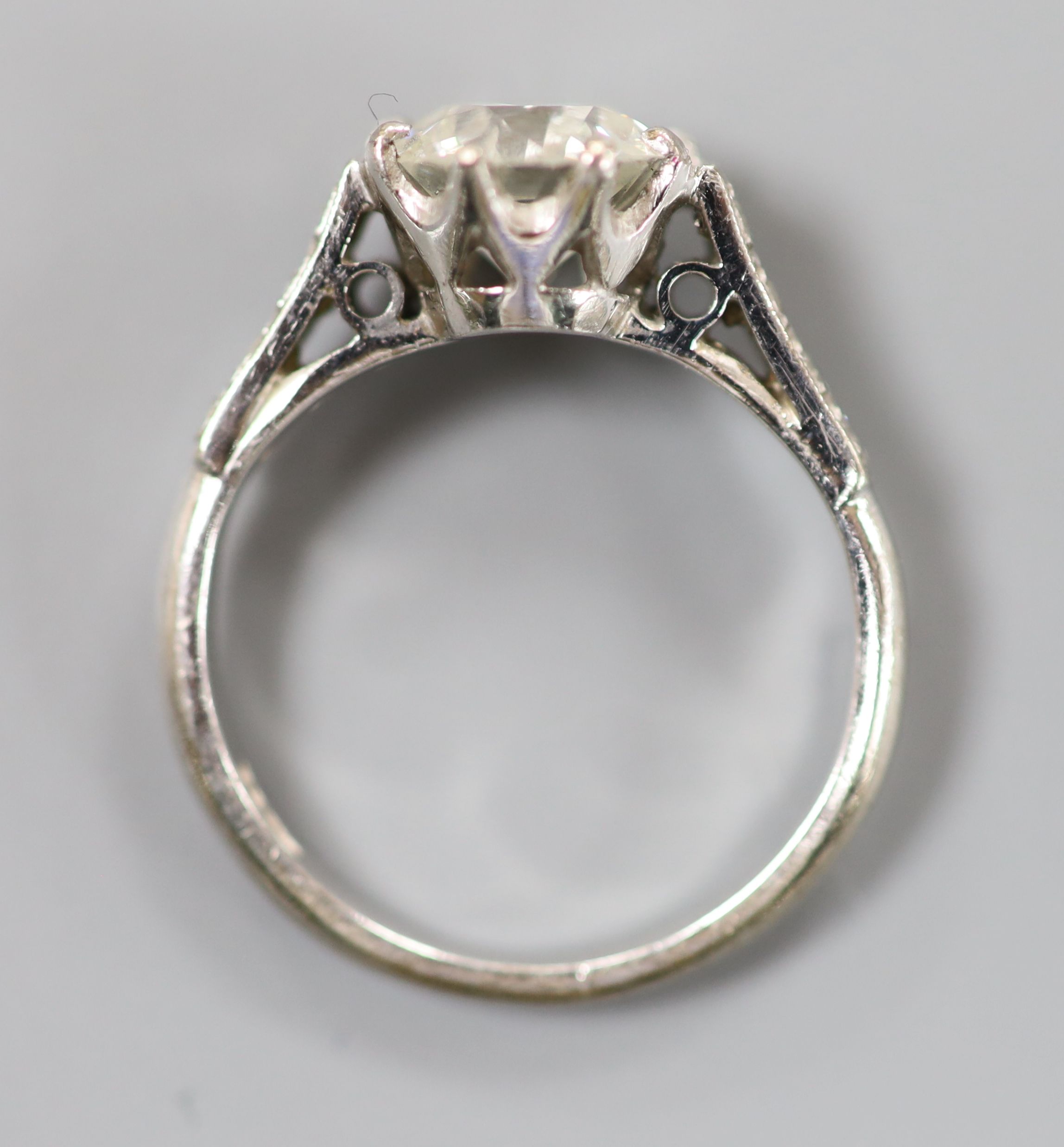 A white metal (stamped 18ct) and single stone diamond ring